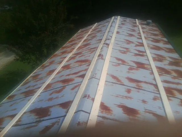 Rusted metal roof panels with new wood purlins before replacement — Storm Damage Roof Repair in Lockhart by Roofing Brothers