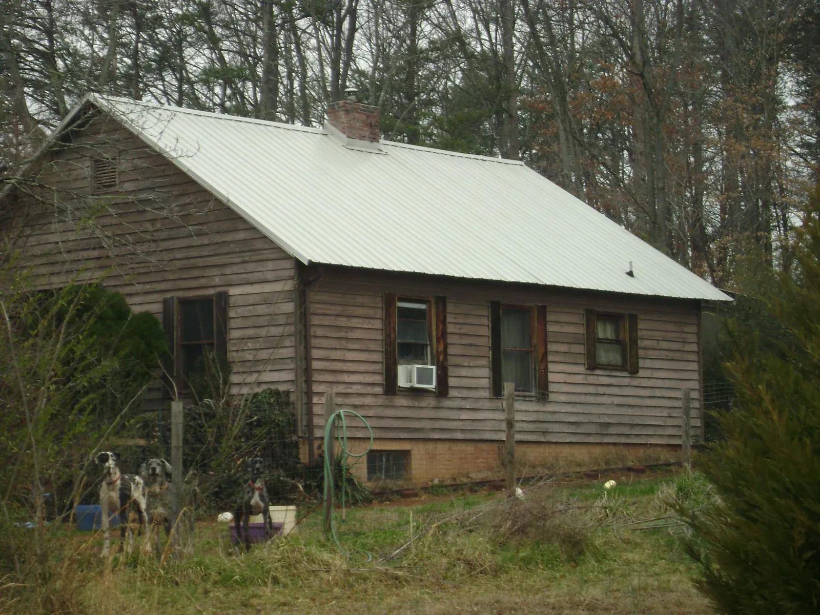 White metal roof on an old wood sided farmhouse, from a Asphalt Shingle Roof Repair job in Lockhart